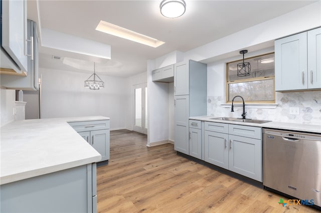 kitchen featuring stainless steel dishwasher, decorative light fixtures, gray cabinetry, and sink