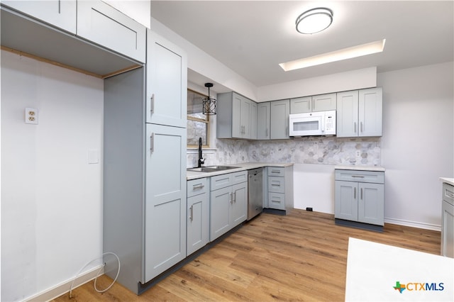 kitchen featuring tasteful backsplash, gray cabinetry, sink, pendant lighting, and dishwasher