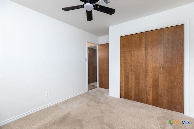 unfurnished bedroom with ceiling fan, light colored carpet, and a closet