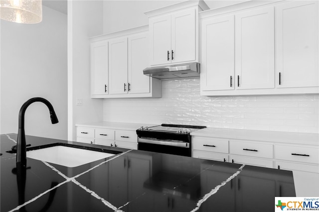 kitchen featuring stainless steel electric stove, decorative backsplash, and white cabinetry