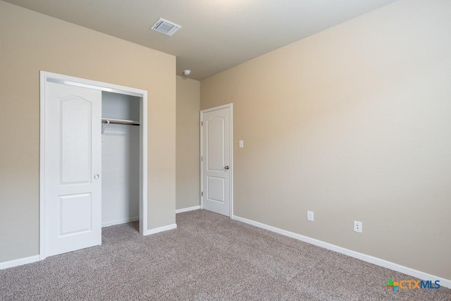 unfurnished bedroom with light carpet and a closet