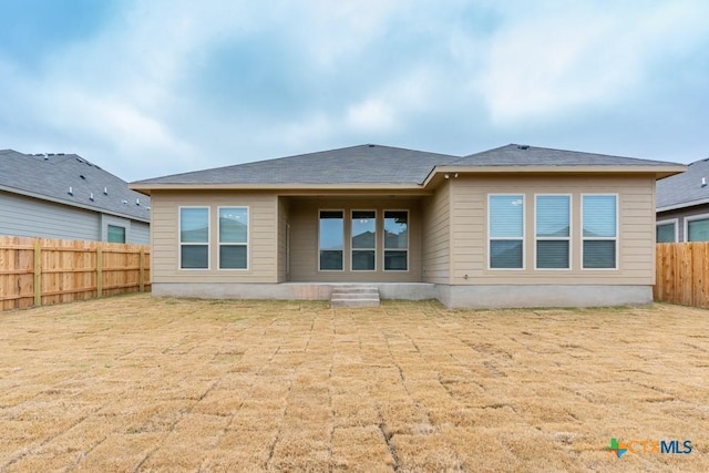 rear view of property featuring a yard