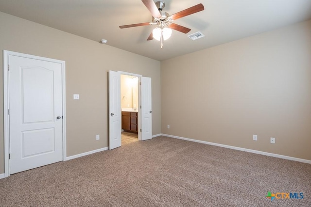 unfurnished bedroom with ceiling fan, light colored carpet, and ensuite bath