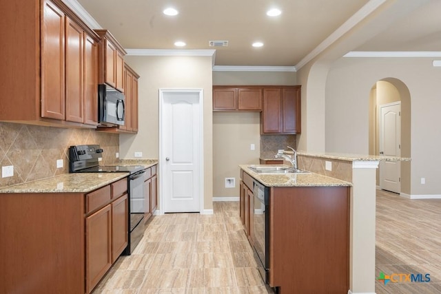 kitchen with light stone counters, sink, a kitchen island with sink, and black appliances