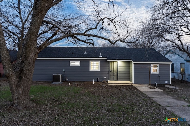 exterior space featuring a shingled roof and central AC unit