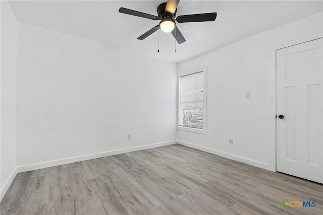 unfurnished bedroom with light wood-type flooring, baseboards, and a ceiling fan