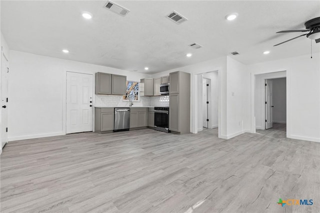 kitchen with visible vents, appliances with stainless steel finishes, gray cabinets, light countertops, and backsplash