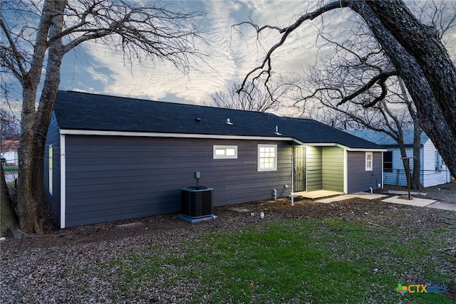 back of property featuring a shingled roof, fence, and central air condition unit