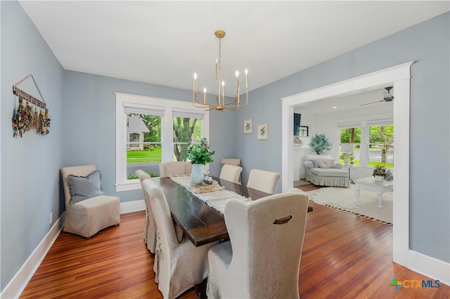 dining space with wood-type flooring and a notable chandelier