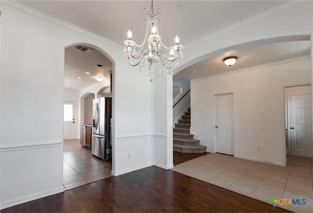 unfurnished room featuring a chandelier, hardwood / wood-style floors, and ornamental molding