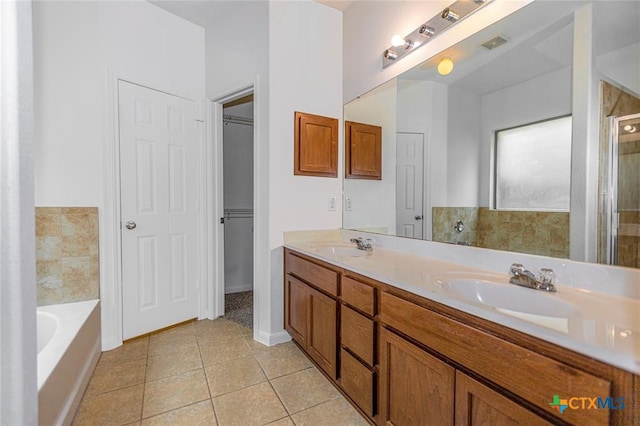 bathroom featuring tile patterned flooring, vanity, and a washtub