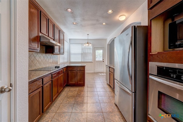 kitchen with decorative backsplash, stainless steel appliances, decorative light fixtures, an inviting chandelier, and light tile patterned flooring