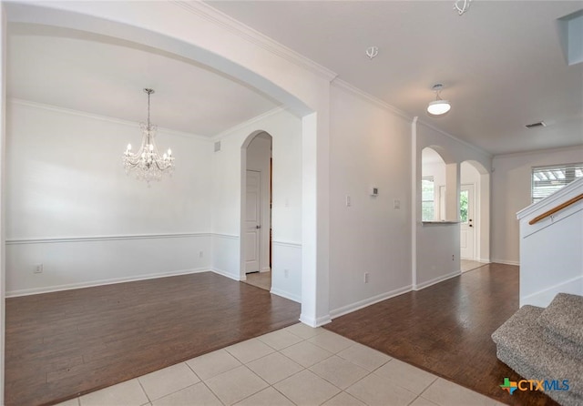 unfurnished room with a chandelier, light hardwood / wood-style flooring, and crown molding