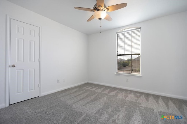 carpeted empty room featuring ceiling fan