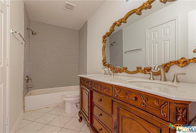 full bathroom with vanity, tiled shower / bath combo, and toilet