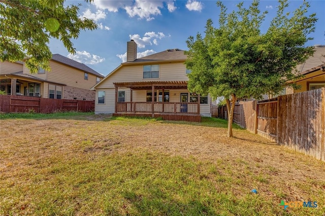 back of house with a pergola, a deck, and a lawn