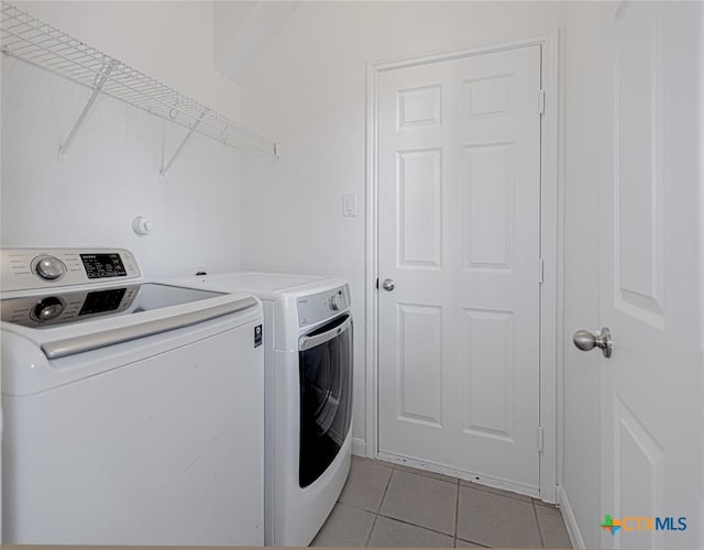 washroom featuring washer and clothes dryer and light tile patterned floors