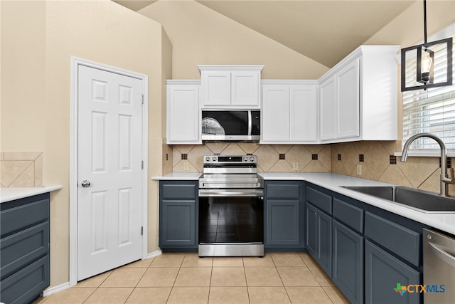 kitchen with sink, appliances with stainless steel finishes, lofted ceiling, white cabinets, and gray cabinets