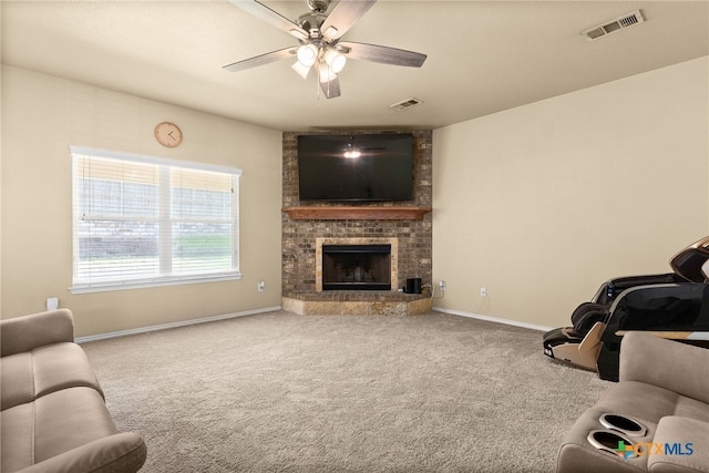 carpeted living room with a fireplace and ceiling fan