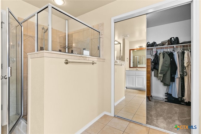 bathroom with tile patterned flooring, vanity, and a shower with shower door