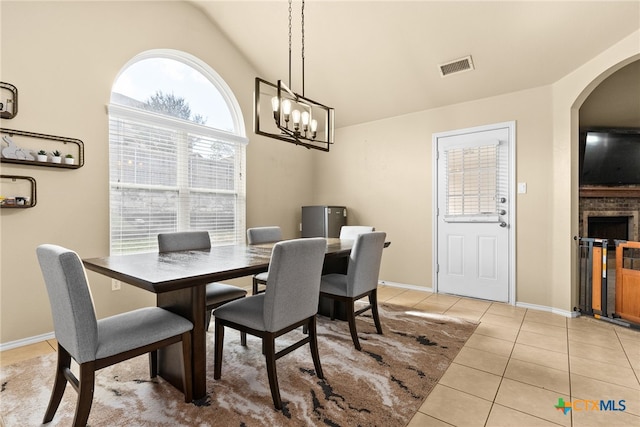 tiled dining room with a chandelier and high vaulted ceiling