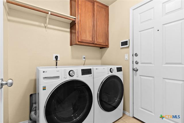 clothes washing area featuring cabinets, light tile patterned floors, and separate washer and dryer