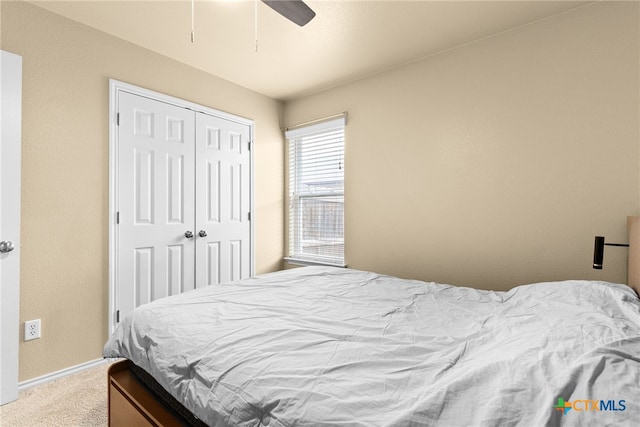 carpeted bedroom with ceiling fan and a closet