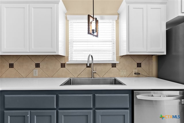 kitchen with decorative backsplash, stainless steel dishwasher, sink, and white cabinets