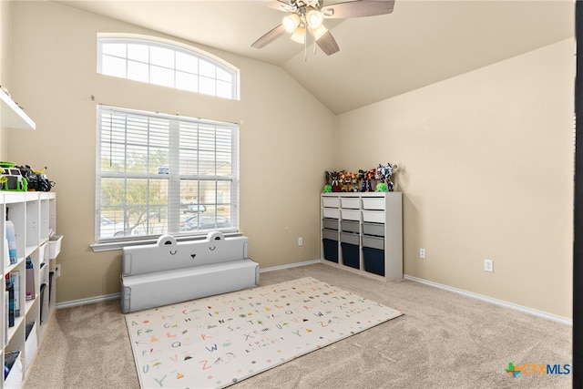 sitting room featuring ceiling fan, light colored carpet, a healthy amount of sunlight, and lofted ceiling