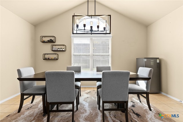 tiled dining room featuring a chandelier and vaulted ceiling