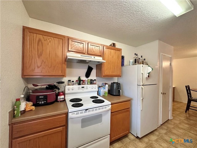 kitchen with white appliances and a textured ceiling