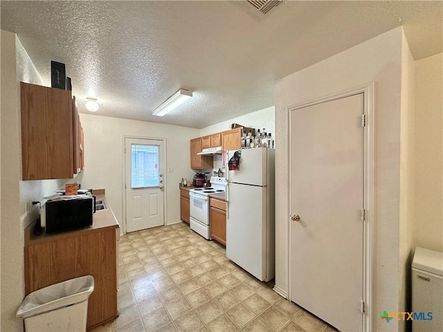 kitchen with white appliances and a textured ceiling