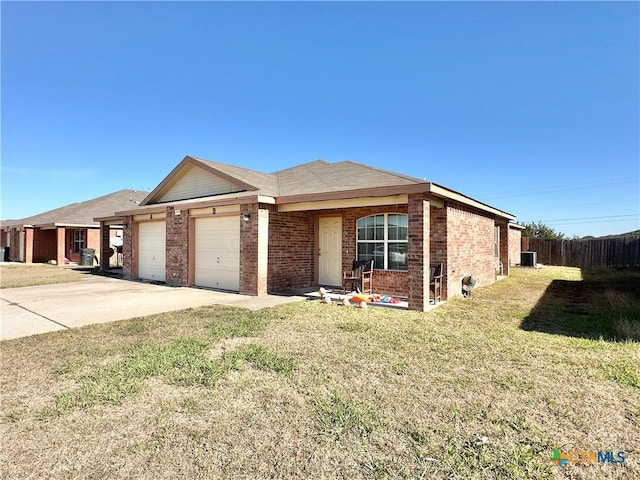 single story home with cooling unit, a front yard, and a garage