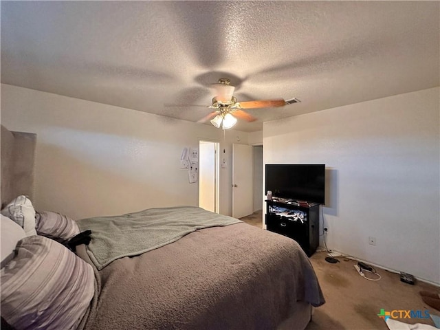 bedroom with carpet, ceiling fan, and a textured ceiling