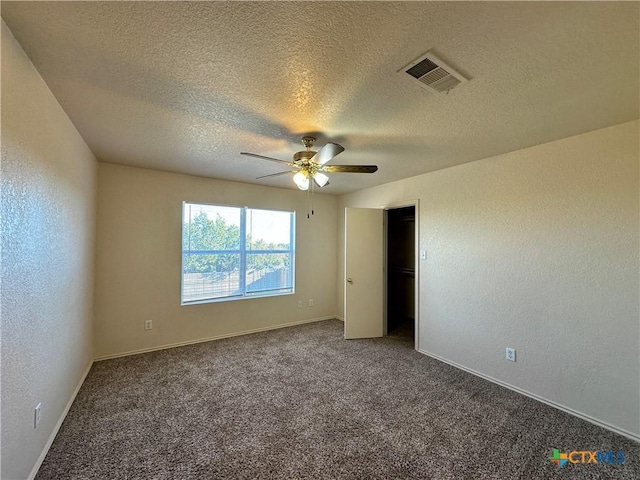 spare room with ceiling fan, carpet, and a textured ceiling