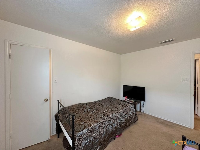 bedroom featuring carpet and a textured ceiling