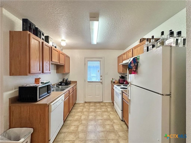 kitchen featuring a textured ceiling, sink, and white appliances