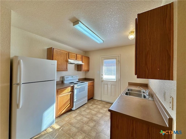 kitchen with a textured ceiling, white appliances, and sink