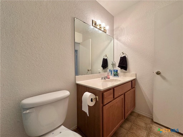 bathroom featuring tile patterned floors, vanity, and toilet