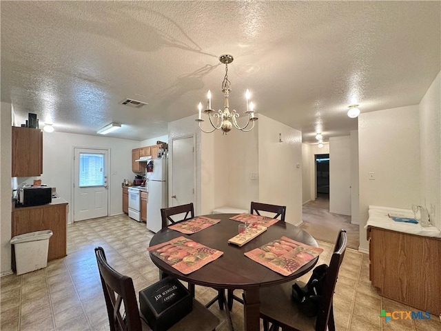 dining room with a textured ceiling and an inviting chandelier