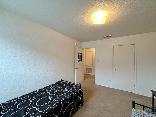 bedroom featuring carpet floors and a textured ceiling