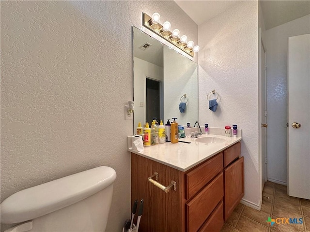 bathroom featuring tile patterned floors, vanity, and toilet