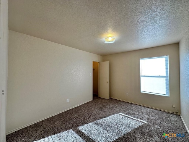 carpeted empty room with a textured ceiling