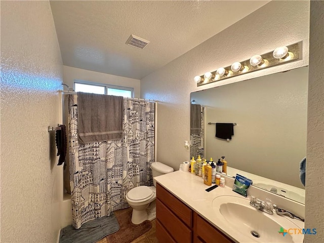 full bathroom featuring vanity, shower / tub combo, a textured ceiling, and toilet