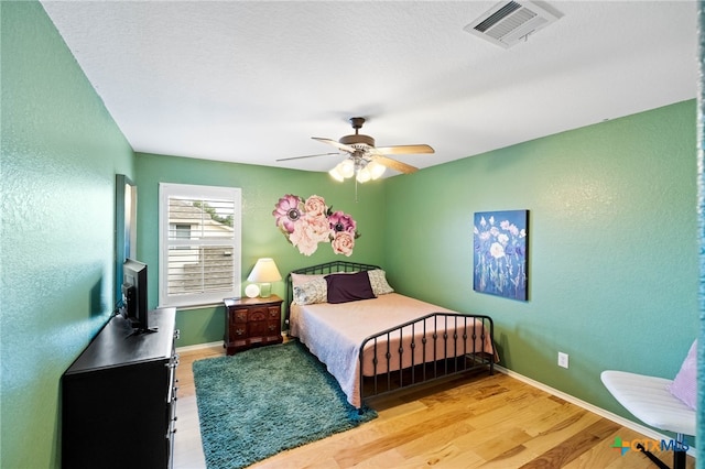 bedroom with light wood-type flooring and ceiling fan