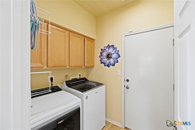 washroom with cabinets, separate washer and dryer, and light tile patterned floors