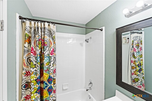 bathroom with shower / tub combo and a textured ceiling