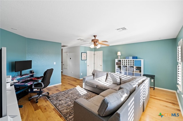 living room featuring light wood-type flooring and ceiling fan