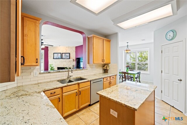 kitchen with sink, stainless steel dishwasher, ceiling fan, tasteful backsplash, and light stone counters