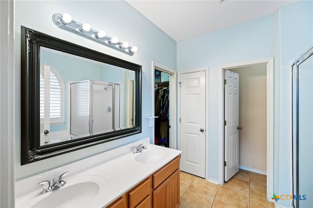 bathroom with tile patterned floors, a shower with door, and vanity